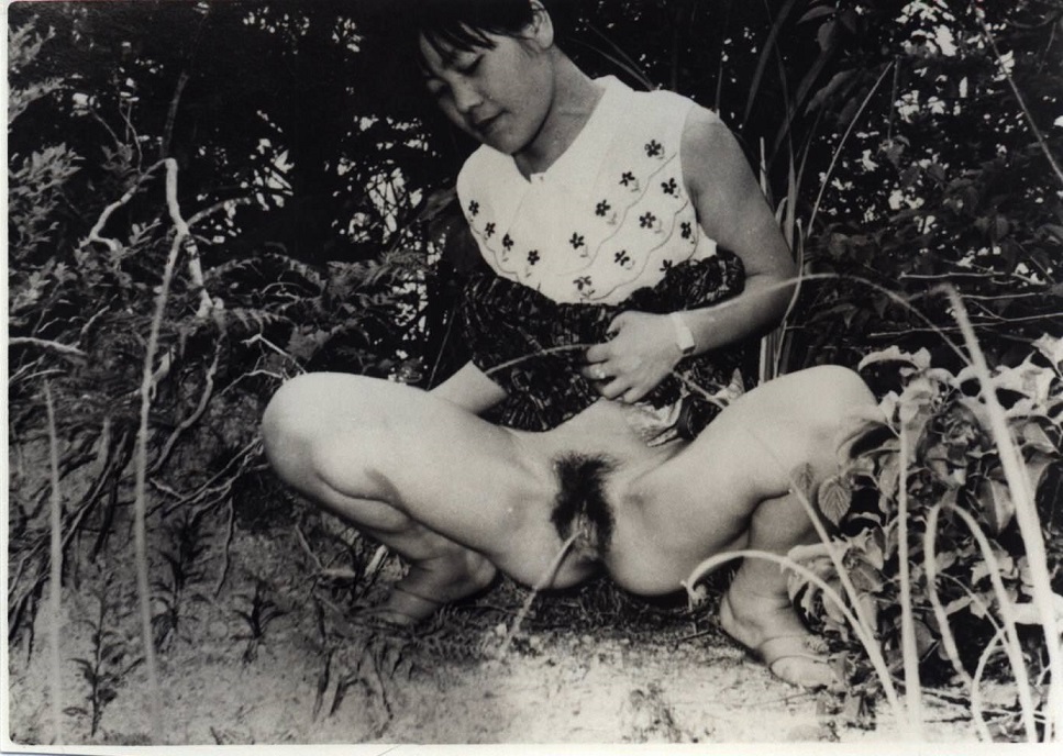Black and white photograph of a young Japanese peeing beauty.