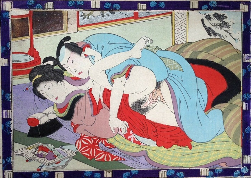 An amorous couple closely examines the images in a shunga book during their love-making